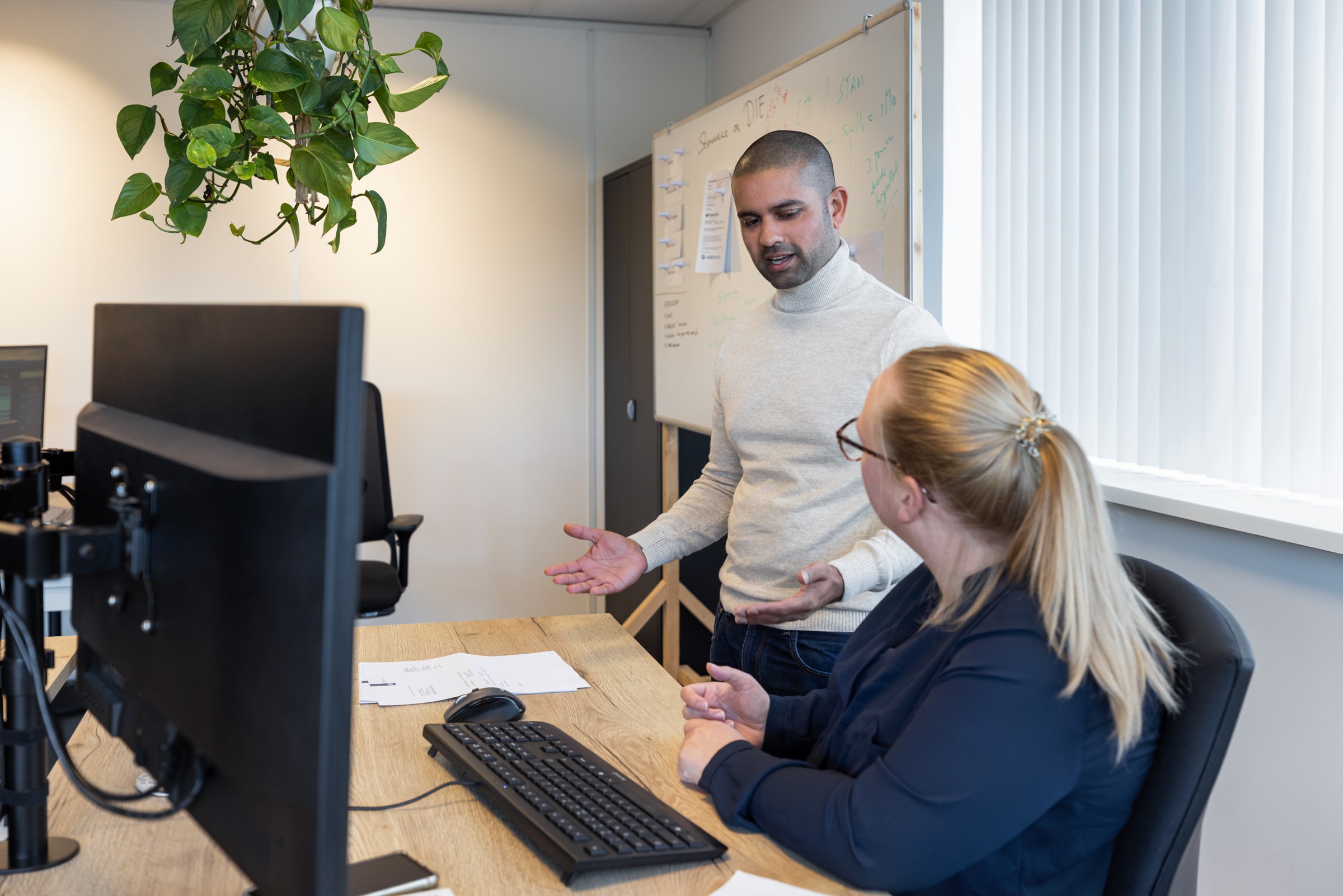 man en vrouw achter computer in overleg